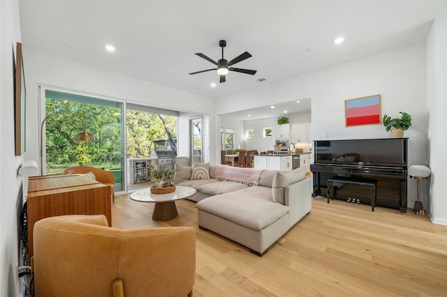 living room with light hardwood / wood-style floors and ceiling fan