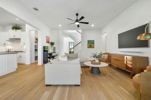 living room featuring light wood-type flooring and ceiling fan