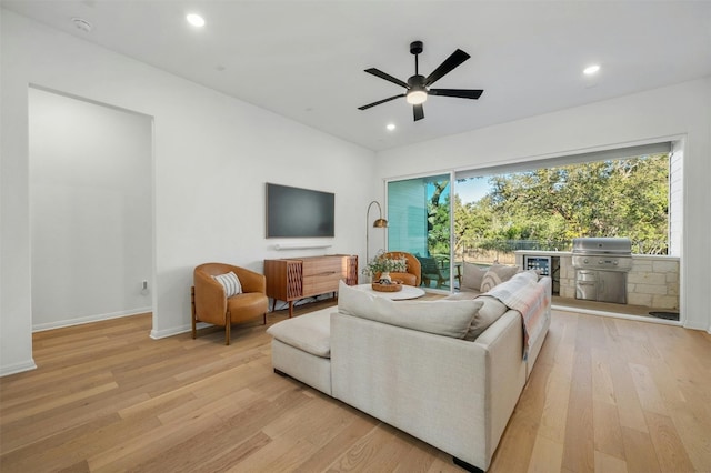 living room featuring ceiling fan and light hardwood / wood-style flooring