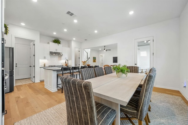 dining area featuring light wood-type flooring and ceiling fan