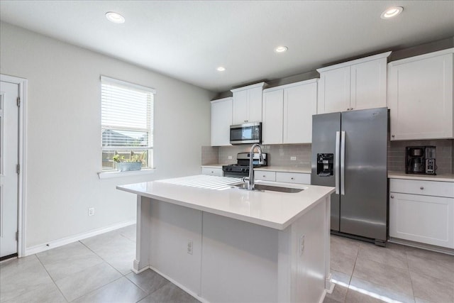 kitchen with white cabinets, a center island with sink, appliances with stainless steel finishes, and tasteful backsplash