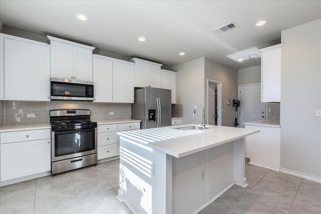 kitchen featuring sink, white cabinetry, light tile patterned floors, a center island with sink, and appliances with stainless steel finishes