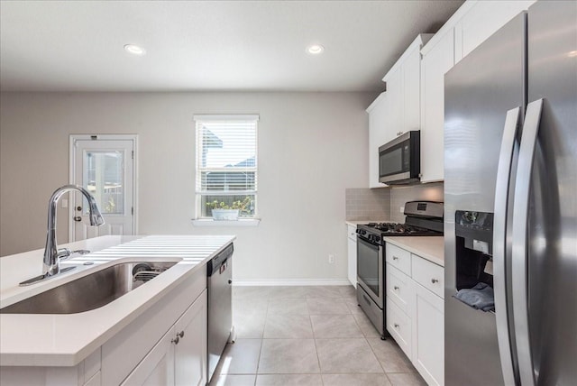 kitchen with stainless steel appliances, white cabinets, and sink