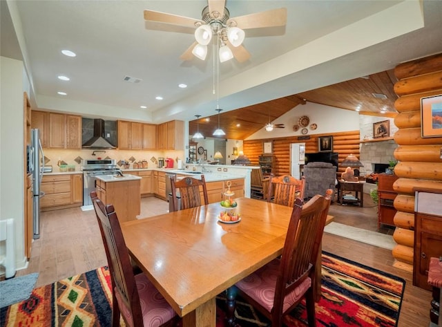 dining room with lofted ceiling, sink, light wood-type flooring, ceiling fan, and log walls