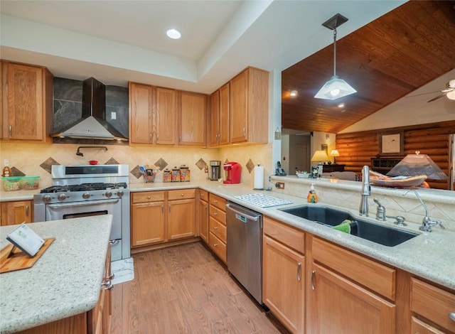 kitchen featuring pendant lighting, sink, stainless steel appliances, light hardwood / wood-style floors, and wall chimney exhaust hood