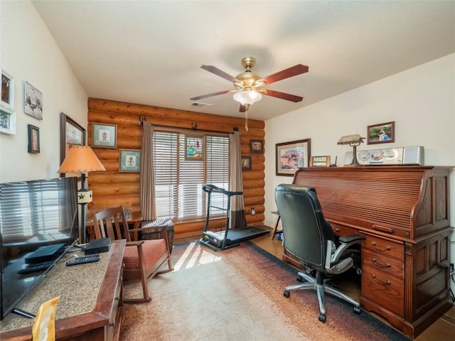 office space featuring rustic walls and ceiling fan