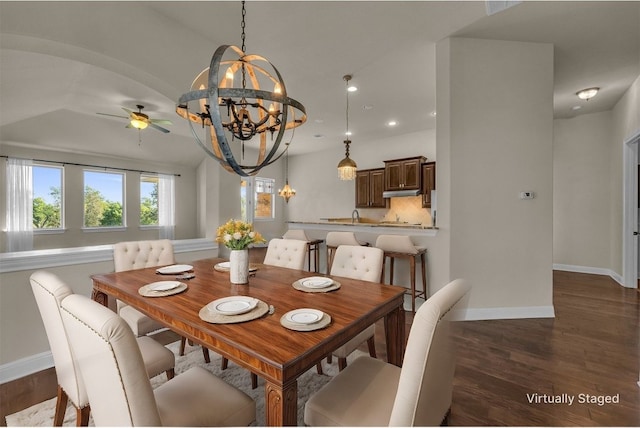 dining space featuring vaulted ceiling, ceiling fan with notable chandelier, and dark hardwood / wood-style floors