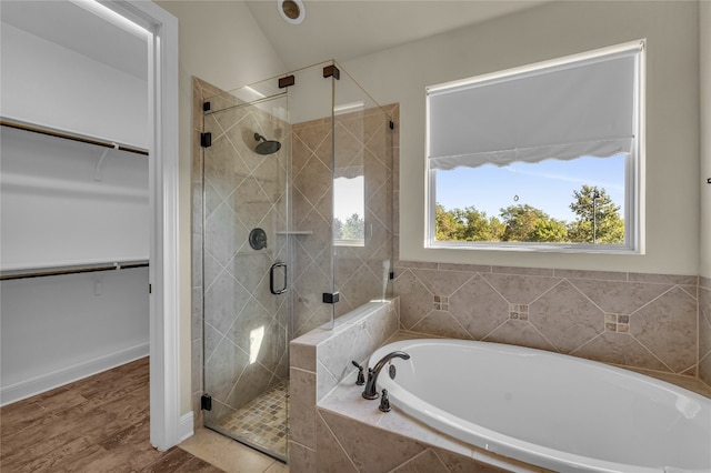 bathroom featuring hardwood / wood-style floors, separate shower and tub, and vaulted ceiling