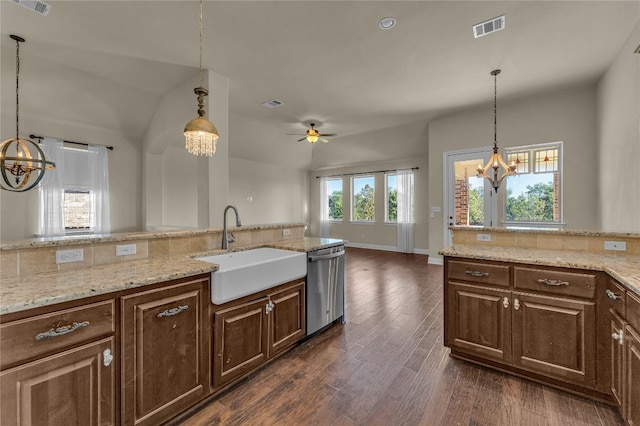 kitchen with stainless steel dishwasher, ceiling fan with notable chandelier, dark wood-type flooring, sink, and pendant lighting