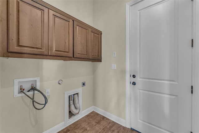 laundry area with hookup for an electric dryer, hookup for a washing machine, cabinets, gas dryer hookup, and wood-type flooring