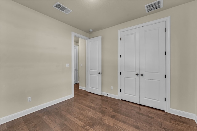 unfurnished bedroom featuring dark hardwood / wood-style floors and a closet