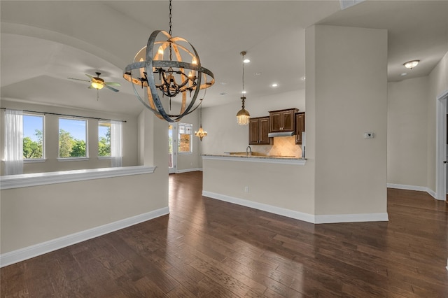 unfurnished living room with lofted ceiling, dark hardwood / wood-style flooring, and ceiling fan with notable chandelier