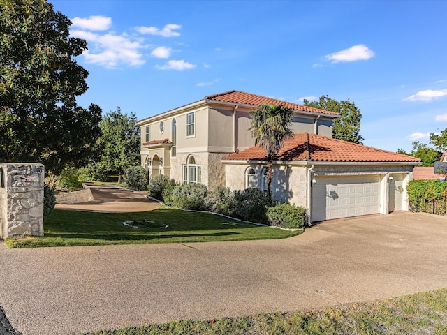 mediterranean / spanish home featuring a garage and a front yard