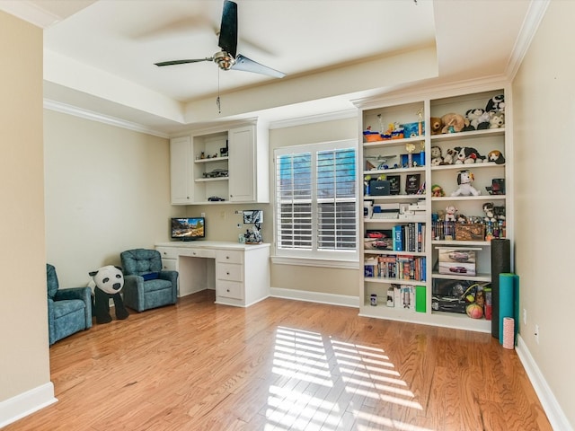 office space featuring a raised ceiling, light hardwood / wood-style flooring, ceiling fan, and ornamental molding