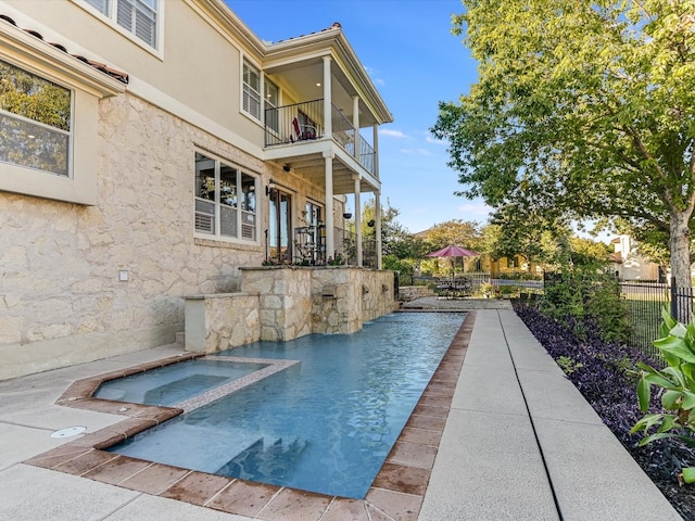 view of swimming pool with an in ground hot tub