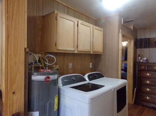 laundry room with cabinets, separate washer and dryer, electric water heater, dark hardwood / wood-style floors, and wood walls