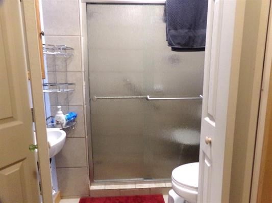 bathroom with toilet and a shower with shower door