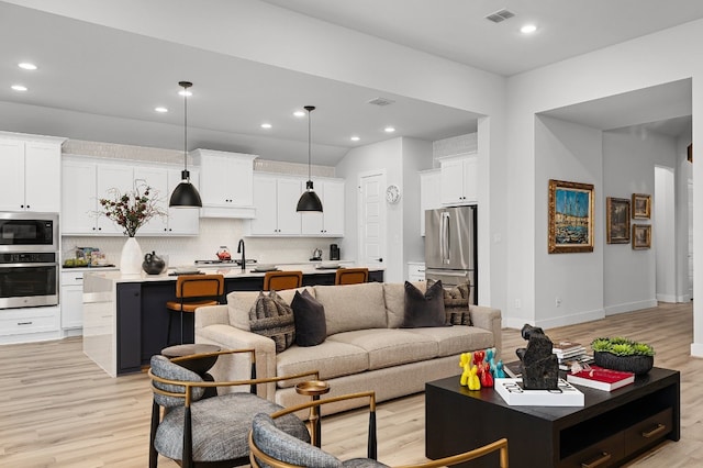 living room with sink and light hardwood / wood-style floors