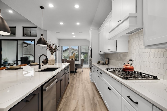 kitchen with sink, hanging light fixtures, and white cabinets