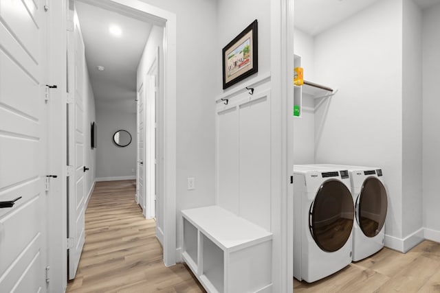 laundry room featuring washer and dryer and light wood-type flooring