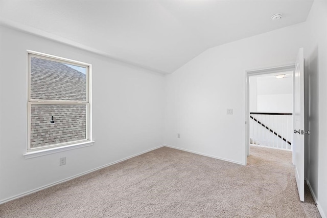 unfurnished room featuring light colored carpet and lofted ceiling