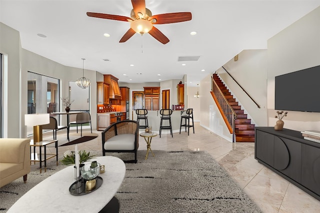 living room with ceiling fan with notable chandelier