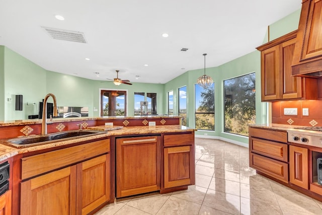 kitchen with ceiling fan with notable chandelier, sink, hanging light fixtures, decorative backsplash, and light tile patterned floors