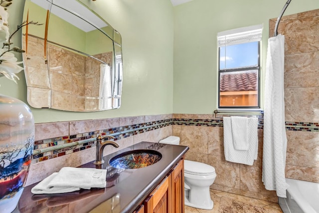 full bathroom featuring tile patterned flooring, shower / bath combination with curtain, toilet, vanity, and tile walls