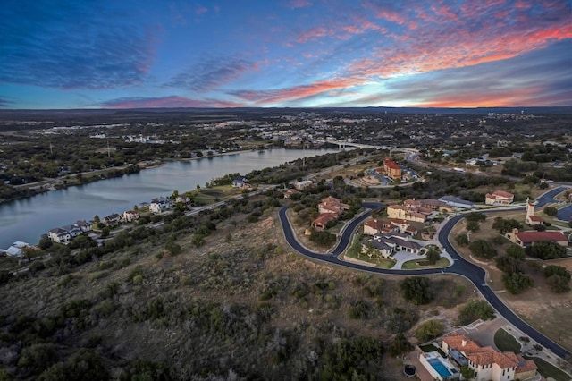 aerial view at dusk featuring a water view