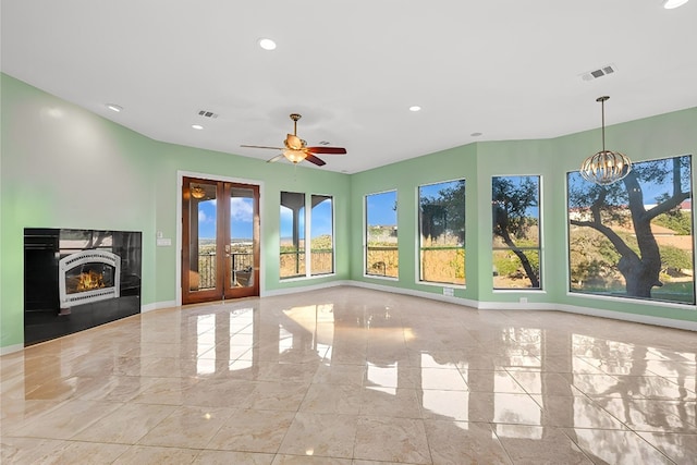 unfurnished sunroom featuring ceiling fan with notable chandelier