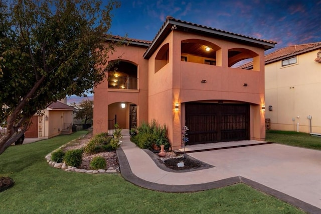 mediterranean / spanish house featuring a yard, a balcony, and a garage