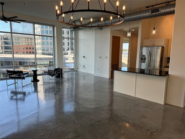 interior space with decorative light fixtures, stainless steel refrigerator with ice dispenser, light brown cabinetry, and a chandelier