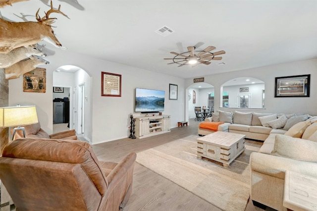 living room with light hardwood / wood-style flooring and ceiling fan