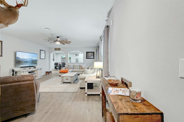 living room with ceiling fan and light wood-type flooring