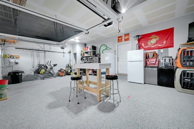 garage with stainless steel refrigerator and white refrigerator