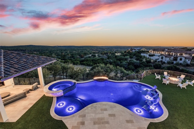 pool at dusk with an in ground hot tub, an outdoor fire pit, and a patio