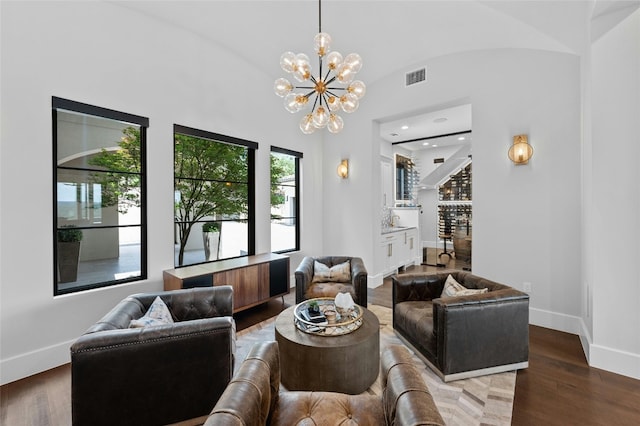 living room featuring a chandelier, hardwood / wood-style flooring, and lofted ceiling