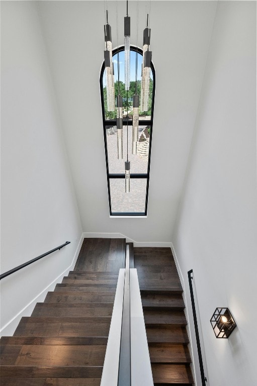 stairway with a chandelier and hardwood / wood-style flooring