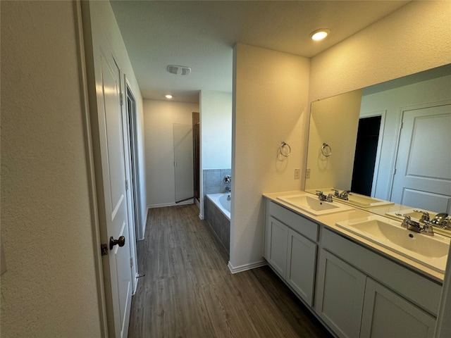 bathroom with vanity, wood-type flooring, and shower with separate bathtub