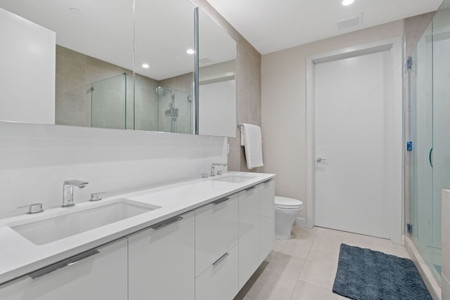 bathroom featuring tile patterned floors, vanity, toilet, and an enclosed shower