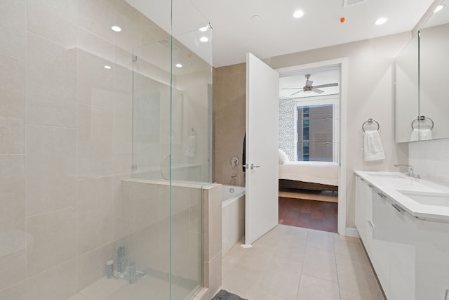 bathroom with tile patterned flooring, ceiling fan, walk in shower, and vanity