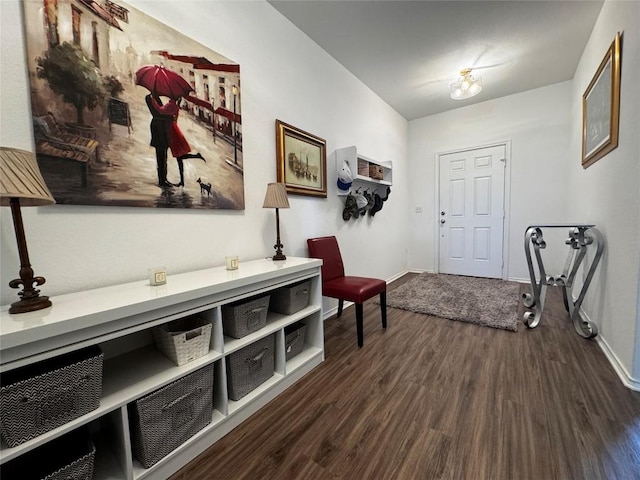 entryway with dark wood finished floors and baseboards