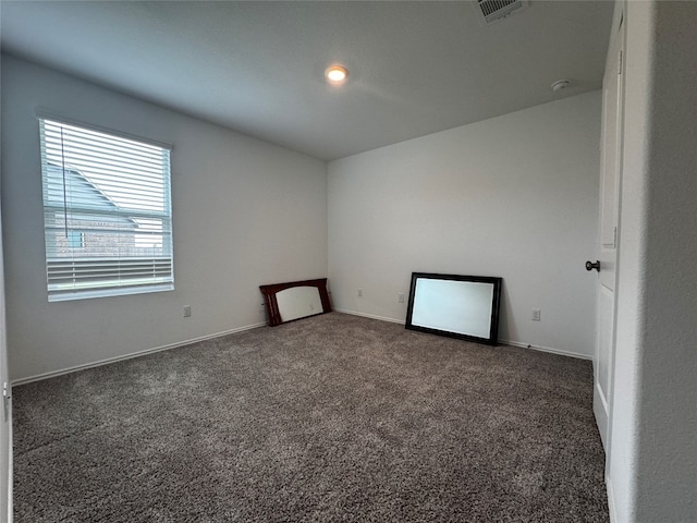 spare room with baseboards, visible vents, and carpet flooring