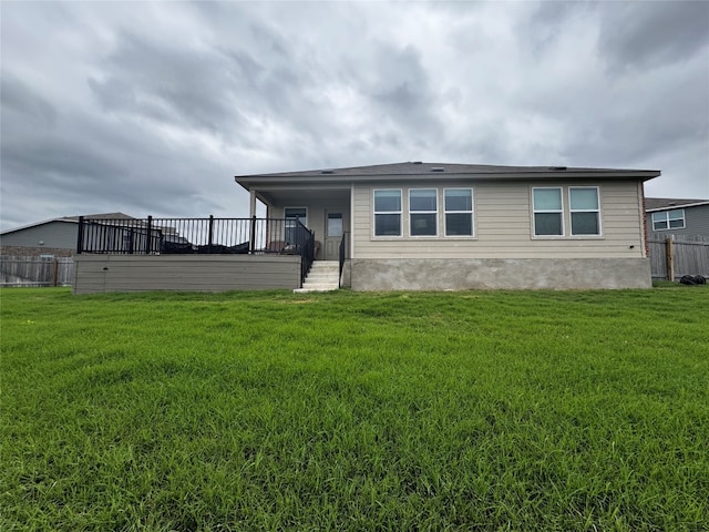 rear view of property featuring fence and a yard