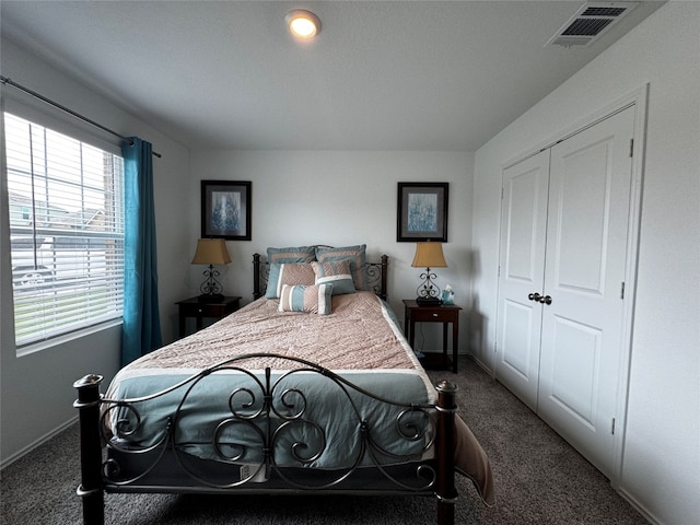 carpeted bedroom with a closet, visible vents, and baseboards