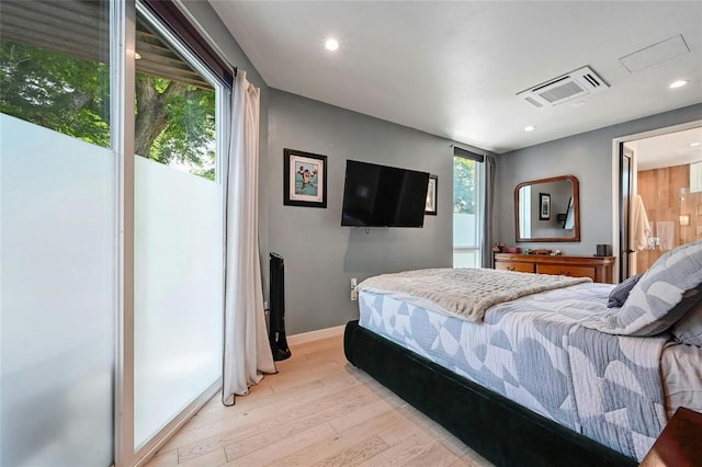 bedroom with light hardwood / wood-style flooring and multiple windows