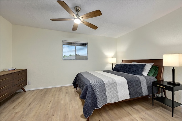 bedroom featuring a textured ceiling, light hardwood / wood-style floors, and ceiling fan