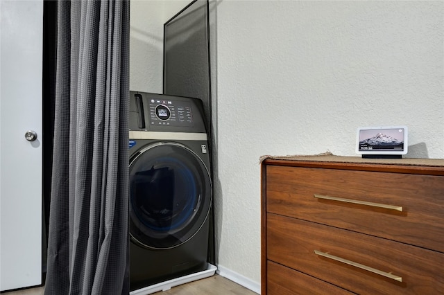 clothes washing area featuring washer / dryer and wood-type flooring