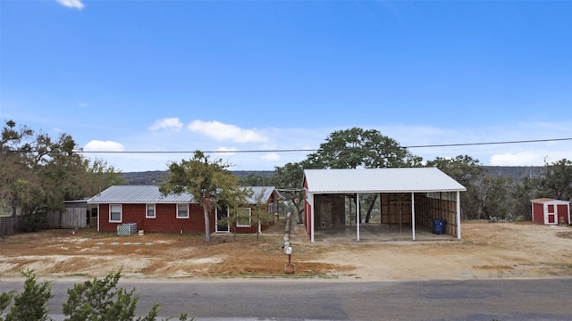 view of front of house with a carport and an outdoor structure