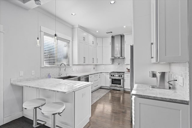 1503 Juliet St, Austin, TX 78704 - kitchen with stainless steel appliances, wall chimney range hood, a peninsula, tasteful backsplash, and light stone counters